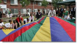 Mrs. Laura Bush joins the children and staff of the Meadowbrook Collaborative Community Center in playing with a colorful parachute during her visit to the facility Tuesday, June 6, 2006 in St. Louis Park, Minn. White House photo by Shealah Craighead