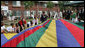 Mrs. Laura Bush joins the children and staff of the Meadowbrook Collaborative Community Center in playing with a colorful parachute during her visit to the facility Tuesday, June 6, 2006 in St. Louis Park, Minn. White House photo by Shealah Craighead