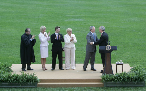 President George W. Bush congratulates former Idaho Gov. Dirk Kempthorne, as Kempthorne’s family and Supreme Court Justice Antonin Scalia, left, applaud following the swearing-in ceremony for Kempthorne as the new U.S. Secretary of Interior, Wednesday, June 7, 2006 on the South Lawn of the White House in Washington. White House photo by David Bohrer