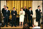 Mrs. Laura Bush stands with members of the cast from the Tony award-winning musical Jersey Boys perform during a luncheon for Senate Spouses in the East Room Monday, June 12, 2006. White House photo by Shealah Craighead