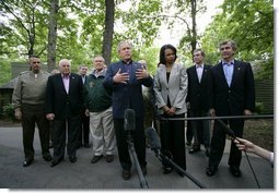 President George W. Bush, surrounded by members of his Cabinet and his national security team, talks with reporters Monday afternoon, June 12, 2006 in Camp David, Md., during the first day of a two-day meeting on Iraq. President Bush is joined by, from left to right, Chairman of the Joint Cheifs of Staff General Peter Pace, Vice President Dick Cheney, Secretary of Defense Donald Rumsfeld, Secretary of State Condoleezza Rice, Secretary of Commerce Carlos Gutierrez and Secretary of Agriculture Mike Johanns.  White House photo by Eric Draper