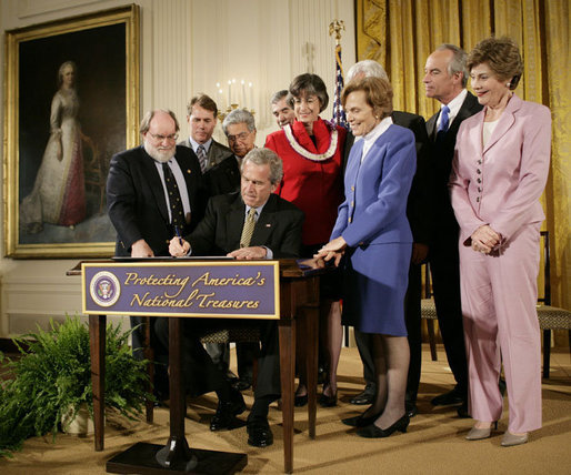 President George W. Bush signs a proclamation to create the Northwestern Hawaiian Islands Marine National Monument at a ceremony Wednesday, June 15, 2006, in the East Room of the White House. The proclamation will bring nearly 140,000 square miles of the Northwestern Hawaiian Island Coral Reef Ecosystem under the nation's highest form of marine environmental protection. Mrs. Laura Bush joined the President and distinguished guests on stage, from left to right, U.S. Rep. Neil Abercrombie, D-Hawaii; U.S. Rep. Ed Case, D-Hawaii; U.S. Sen. Daniel Akaka, D-Hawaii; U.S. Commerce Secretary Carlos Gutierrez; Hawaii Gov. Linda Lingle; documentary filmmaker Jean-Michel Cousteau; marine biologist Sylvia Earle and U.S. Interior Secretary Dirk Kempthorne. White House photo by Eric Draper