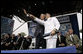 President George W. Bush waves to the audience with a recent graduate during the graduation ceremony at the United States Merchant Marine Academy at Kings Point, New York, Monday, June 19, 2006. White House photo by Kimberlee Hewitt