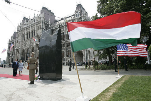 President George W. Bush and Mrs. Laura Bush stand in silence after laying flowers at the eternal flame of the 1956 Memorial Monument outside the Hungarian Parliament in Budapest, Hungary, Thursday, June 22, 2006. The monument honors victims of the 1956 Hungarian uprising against Soviet rule. White House photo by Eric Draper