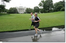 President George W. Bush runs with U.S. Army Staff Sergeant Christian Bagge, 23, of Eugene, Ore., on the South Lawn Tuesday, June 27, 2006. President Bush met Sgt. Bagge at Brooke Army Medical Center Jan. 1, 2006, where he promised to run with Sgt. Bagge. Since then, Sgt. Bagge has reenlisted to active duty. White House photo by Eric Draper