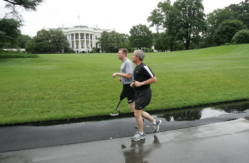 President George W. Bush runs with U.S. Army Staff Sergeant Christian Bagge, 23, of Eugene, Ore., on the South Lawn Tuesday, June 27, 2006. President Bush met Sgt. Bagge at Brooke Army Medical Center Jan. 1, 2006, where he promised to run with Sgt. Bagge. Since then, Sgt. Bagge has reenlisted to active duty. White House photo by Eric Draper