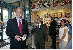 President George W. Bush offers to buy a cup of coffee for a member of the media during a stop at Dunkin' Donuts in Alexandria, Va., July 5, 2006. "We need to make sure we help people assimilate. I met four people here who assimilated into our country. They speak English; they understand the history of our country; they love the American flag as much as I love the American flag," said the President. "That's one of the great things about America, we help newcomers assimilate. Here's four folks that are living the American Dream, and I think it helps renew our soul and our spirit to help people assimilate." White House photo by Kimberlee Hewitt