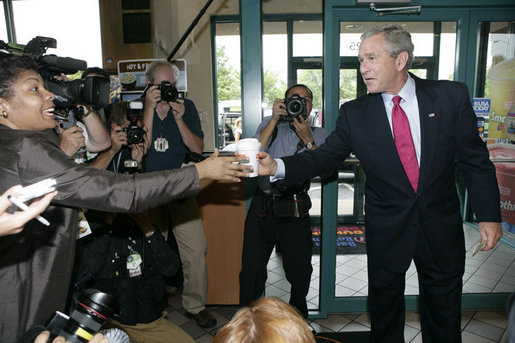 President George W. Bush offers to buy a cup of coffee for a member of the media during a stop at Dunkin' Donuts in Alexandria, Va., July 5, 2006, where President Bush spoke in support of the Basic Pilot Program to verify employment eligibility. White House photo by Kimberlee Hewitt