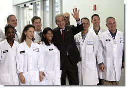 President George W. Bush stands with a group of employees as he waves to others during a tour of the Cabot Microelectronics Corporation facility in Aurora, Ill., Friday, July 7, 2006. White House photo by Eric Draper