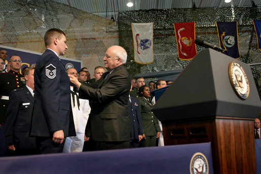 Vice President Dick Cheney pins the Purple Heart Medal onto Master Sergeant Henry G. Christle, Jr., Monday, July 10, 2006, during a rally for the Michigan National Guard and Joint Services at Selfridge Air National Guard Base in Harrison Township, Mich. Master Sergeant Christle was wounded in action on March 23, 2004 while serving as a Special Operations Weather Team Forecaster and Observer assigned to the Combined Joint Special Operations Task Force 180, Afghanistan. White House photo by David Bohrer