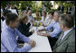 President George W. Bush shares a conversation with Chancellor Angela Merkel of Germany as he and Mrs. Laura Bush enjoy a barbeque dinner in Trinwillershagen as guests of the Chancellor. White House photo by Eric Draper