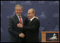 President George W. Bush and President Vladimir Putin exchange handshakes Saturday, July 15, 2006, after a joint press availability at the International Media Center in the Konstantinovsky Palace Complex, site of the G8 Summit in Strelna, Russia. White House photo by Paul Morse