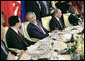 President George W. Bush talks with Chinese President Hu Jintao, left, during a luncheon with world leaders during the G8 Summit at the Konstantinovsky Palace Complex Monday, July 17, 2006 in Strelna, Russia. Also pictured is Russian President Vladimir Putin, and South African President Thabo Mbeki, far-right. White House photo by Eric Draper