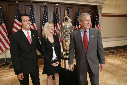 President George W. Bush meets with Sam Hornish Jr., the 2006 winner of the Indianapolis 500, and his wife, Crystal Hornish, as they stand next to the 500 race Borg-Warner Trophy Tuesday, July 18, 2006, at the Eisenhower Executive Office Building in Washington. White House photo by Eric Draper