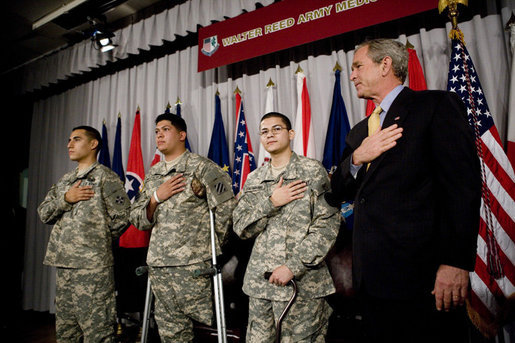 President George W. Bush recites the Pledge of Allegiance Monday, July 24, 2006, at Walter Reed Army Medical Center in Washington, D.C., joining newly sworn-in American citizens, Specialist Sergio Lopez, 24, of Bolingbrook, Ill., left, Specialist Noe Santos-Dilone of Brooklyn, N.Y., center, and Private First Class Eduardo Leal-Cardenas of Los Angeles, Calif., during their naturalization ceremony. White House photo by Eric Draper