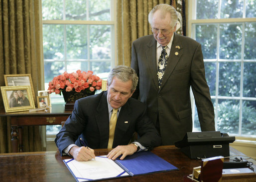 President George W. Bush is joined by U.S. Rep. Roscoe Bartlett, R- Md., as he signs H.R. 42, Freedom to Display the American Flag Act of 2005, Monday, July 24, 2006, in the Oval Office of the White House. The bill prevents a condominium association, cooperative association, or residential real estate management association from denying an owner or resident from displaying the U.S. flag on their residential property within the association. White House photo by Paul Morse