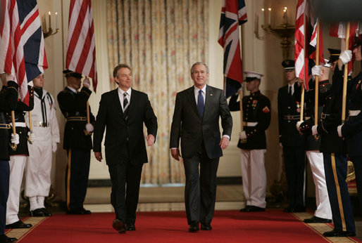 President George W. Bush is joined by Prime Minister Tony Blair of the United Kingdom as they walk through Cross Hall to the East Room of the White House Friday, July 28, 2006, to participate in a joint press availability. White House photo by Paul Morse