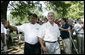 Baseball legend and hall of famer Willie Mays walks with President George W. Bush as he acknowledges a standing ovation from the crowd Sunday, July 30, 2006, upon their arrival for the Tee Ball on the South Lawn game between the Thurmont Little League Civitan Club of Frederick Challengers of Thurmont, Md., and the Shady Spring Little League Challenger Braves of Shady Spring, W. Va. Mays was the honorary Tee Ball Commissioner for the game. White House photo by Paul Morse