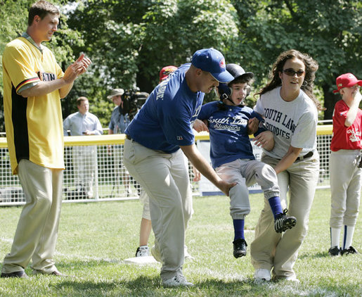 A player for the Shady Spring Little League Challenger Braves of Shady Spring W. Va., is helped around the bases Sunday, July 30, 2006, at the White House Tee Ball on the South Lawn game against the Thurmont Little League Civitan Club of Frederick Challengers of Thurmont, Md. White House photo by Paul Morse