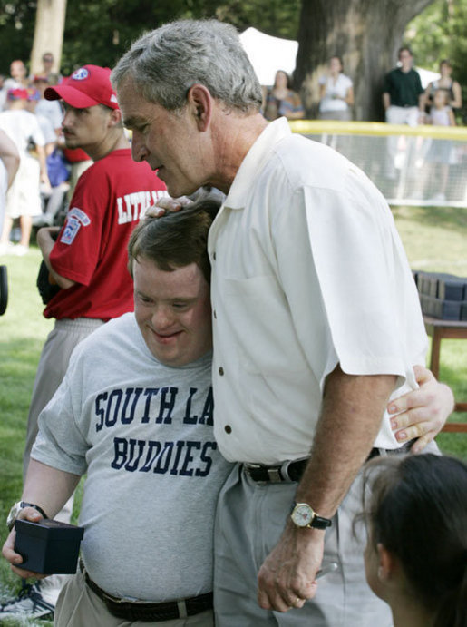 President George W. Bush embraces a South Lawn buddy volunteer Sunday, July 30, 2006, on the South Lawn of the White House at the conclusion of the Tee Ball on the South Lawn game between the Thurmont Little League Civitan Club of Frederick Challengers of Thurmont, Md., and the Shady Spring Little League Challenger Braves of Shady Spring, W. Va. White House photo by Paul Morse