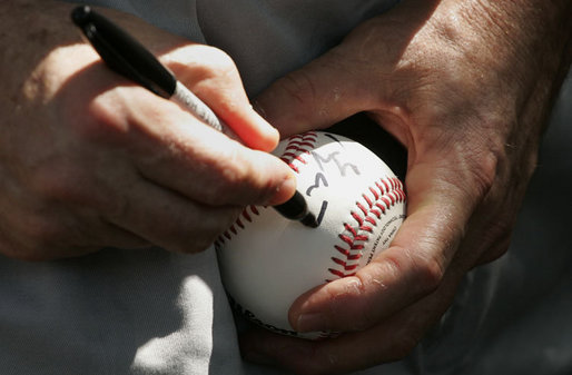 President George W. Bush autographs baseballs for players and guests at the White House Sunday, July 30, 2006, during the Tee Ball on the South Lawn game between the Thurmont Little League Civitan Club of Frederick Challengers of Thurmont, Md., and the Shady Spring Little League Challenger Braves of Shady Spring, W. Va. White House photo by Paul Morse