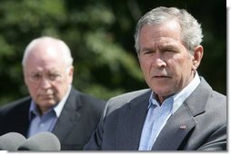 President George W. Bush talks to reporters Friday, Aug. 18, 2006 in Camp David, Md., following a meeting with his economic advisors and Vice President Dick Cheney, seen background. President Bush said the foundation of our economy is strong and is maintaining solid growth. White House photo by David Bohrer