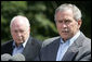 President George W. Bush talks to reporters Friday, Aug. 18, 2006 in Camp David, Md., following a meeting with his economic advisors and Vice President Dick Cheney, seen background. President Bush said the foundation of our economy is strong and is maintaining solid growth. White House photo by David Bohrer