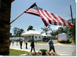 President George W. Bush waves as he is joined by Biloxi Mayor A.J. Holloway, left, Monday, Aug. 28, 2006, during President Bush’s walking tour in the same Biloxi, Miss., neighborhood he visited following Hurricane Katrina in September 2005. The tour allowed President Bush the opportunity to assess the progress of the area’s recovery and rebuilding efforts following the devastating hurricane. White House photo by Eric Draper