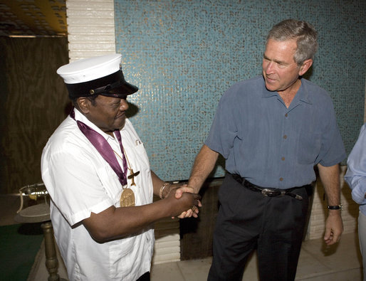 President George W. Bush shakes the hand of legendary Fats Domino, wearing a National Medal of Arts, after the President presented it Tuesday, Aug. 29, 2006, at the musician's home in the Lower 9th Ward of New Orleans. The medal was a replacement medal for the one -- originally awarded by President Bill Clinton -- that was lost in the flood waters of Hurricane Katrina. White House photo by Eric Draper