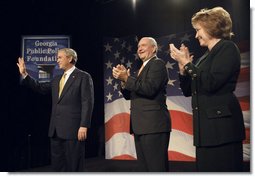 President George W. Bush acknowledges the Atlanta audience as he arrives on stage Thursday, Sept. 7, 2006, at the Cobb Galleria Centre to deliver his remarks on the global war on terror to the Georgia Public Policy Foundation. Joining the applause for the President are Georgia's Gov. Sonny Perdue and Dr. Brenda Fitzgerald, Chairman, Board of Governors, the Georgia Public Policy Foundation. White House photo by Eric Draper