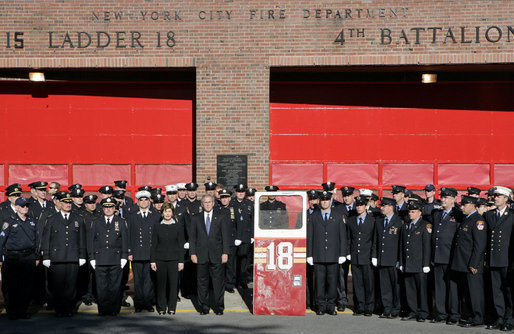 President George W. Bush and Laura Bush stand with New York City First Responders at the Fort Pitt Firehouse for a moment of silence Monday, September 11, 2006, in New York City to commemorate the fifth anniversary of the September 11th terrorist attacks. Also pictured is a door from Ladder 18, which was destroyed in the collapse of the World Trade Center. White House photo by Kimberlee Hewitt