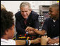 President George W. Bush talks with students during his visit Thursday, Oct. 5, 2006, in the SmartLab of the Woodridge Elementary and Middle Campus in Washington, D.C., where students demonstrated various math, science and technology projects. White House photo by Paul Morse