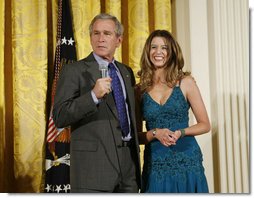 President George W. Bush joins singer Ana Cristina on stage to thank her and guitarist Marco Linares for their performance Friday, Oct. 6, 2006, in the East Room of the White House, in celebration of Hispanic Heritage Month. White House photo by Paul Morse