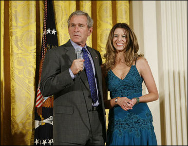 President George W. Bush joins singer Ana Cristina on stage to thank her and guitarist Marco Linares for their performance Friday, Oct. 6, 2006, in the East Room of the White House, in celebration of Hispanic Heritage Month. White House photo by Paul Morse