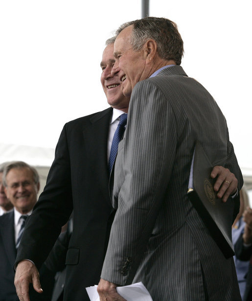 President George W. Bush hugs his father, Former President George H. W. Bush, after delivering remarks at the Christening Ceremony for the George H.W. Bush (CVN 77) in Newport News, Virginia, Saturday, Oct. 7, 2006. White House photo by Eric Draper