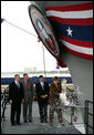 President George W. Bush joins his father, Former President George H. W. Bush and Northrop Grumman President Mike Petters, as his sister Doro Bush Koch breaks the bottle to christen the George H.W. Bush (CVN 77) in Newport News, Virginia, Saturday, Oct. 7, 2006. White House photo by Eric Draper