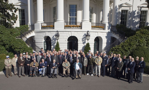 President George W. Bush stands for a photograph with veterans of the 57th Bomb Wing from World War II on the South Portico Friday, Oct. 13, 2006. Approximately 10,800 airmen passed through the portals of the 57th Bomb Wing, a command composed of B-25 Mitchell medium bombers, during its time in combat from 1942 to 1945 in North Africa, Sicily, Corsica, and Italy. The B-25 Mitchell’s and their crews were known for their ability to take out bridges, gun positions, and for disrupting enemy troop communications. The 57th was nicknamed, “The Bridge Busters.” The members are in Washington, D.C., for their association's annual reunion Oct. 11-16, 2006. White House photo by Paul Morse