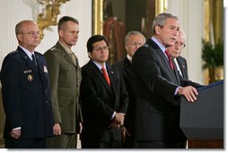 President George W. Bush speaks during the signing of S. 3930, the Military Commissions Act of 2006, Tuesday, Oct. 17, 2006, in the East Room. "It is a rare occasion when a President can sign a bill he knows will save American lives. I have that privilege this morning," said President Bush. Pictured in the background are, from left, Deputy Director of National Intelligence Michael Hayden; General Peter Pace, Chairman of the Joint Chiefs of Staff; Attorney General Alberto Gonzales; Defense Secretary Donald Rumsfeld and Vice President Dick Cheney. White House photo by Paul Morse