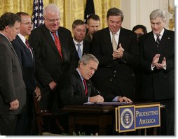 President George W. Bush signs into law S. 3930, the Military Commissions Act of 2006, during a ceremony Tuesday, Oct. 17, 2006, in the East Room of the White House. Joining him on stage, from left are: Utah Rep. Chris Cannon, Indiana Rep. Steve Buyer, Wisconsin Rep. Jim Sensenbrenner, Sen. Lindsey Graham of South Carolina, California Rep. Duncan Hunter, and Sen. John Warner of Virginia. General Peter Pace, Chairman of the Joint Chiefs of Staff, and U.S. Attorney General Alberto Gonzales are in the background. White House photo by Paul Morse