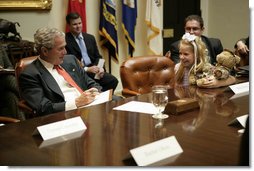 President George W. Bush listens to Bailey Reese, 10, founder of Hero Hugs, which sends care packages to our troops serving overseas, during a meeting with organizations that support the U.S. Military in Iraq and Afghanistan in the Roosevelt Room, Friday, October 20, 2006.  White House photo by Eric Draper