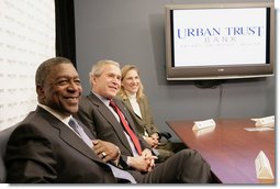 President George W. Bush sits with Bob Johnson, founder and chairman of the RLJ Companies, and Kathy Boden, right, president and CEO of Blue House Water Solutions , during a meeting to discuss the economy with small business owners and community bankers, Monday, Oct. 23, 2006 at the Urban Trust Bank in Washington, D.C. White House photo by Eric Draper