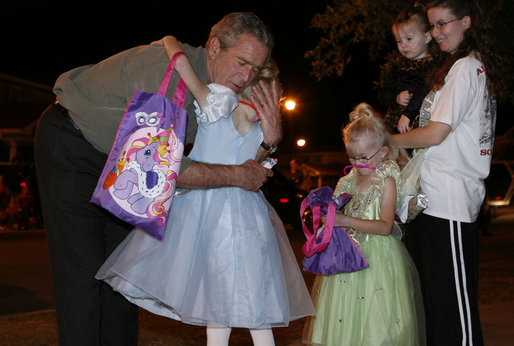 President George W. Bush hugs a trick-or-treater Tuesday, Oct. 31, 2006, during a Halloween visit to a housing development on base at Robins Air Force Base, Ga. White House photo by Paul Morse