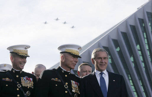 President George W. Bush talks with Chairman of the Joint Chiefs of Staff General Peter Pace, left, and Commandant of the Marine Corps, General Michael Hagee, as a fly over approaches at the dedication ceremony of the National Museum of the Marine Corps Friday, Nov. 10, 2006, in Quantico, Va. White House photo by Paul Morse