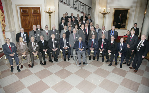 President George W. Bush and Mrs. Laura Bush stand with members of the 555th Anti-aircraft Artillary (Automatic Weapons) Battalion (555 AAA Battalion) at the White House Veteran's Day reception Saturday, Nov. 11, 2006. Mrs Bush's father, Harold B. Welch, served as Battalion Master Gunner in the "Five-by-Five." Two survivors from the Nazi concentration camp Nordhausen were also in attendance at the reception. The 555 AAA Battalion was attached to the 104th Infantry Division, which liberated the Nazi concentration camp Nordhausen on April 12, 1945. White House photo by Kimberlee Hewitt