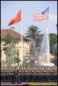 Under the American and Viet flags, President George W. Bush and President Nguyen Minh Triet review the honor guard during the arrival ceremony Friday, Nov. 17, 2006, in Hanoi. White House photo by Shealah Craighead