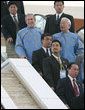 President George W. Bush takes an escalator at the National Convention Center in Hanoi, en route to APEC Island for the 2006 official portrait. To his right is Morris Chang, the APEC representative from Taiwan. White House photo by Eric Draper