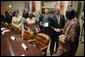 President George W. Bush welcomes Cyriaque Yapo Ako, executive director of the Reseau Ivoirien des Organisations de PVVIH in Cote d’Ivoire, Africa, to the White House World AIDS Day meeting hosted by President Bush and Laura Bush, Friday, Dec. 1, 2006. Participants included supporters of the President’s Emergency Plan for AIDS Relief (PEPFAR), which is the largest international health initiative in history dedicated to a single disease. Angelina Magaga of the Light and Courage Center Trust of Botswana, Africa, is seen center. White House photo by Eric Draper