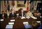 President George W. Bush talks with reporters at a meeting hosted by President Bush and Laura Bush on World AIDS Day in the Roosevelt Room at the White House, Friday, Dec. 1, 2006. President Bush said the United States is committed in helping solve this problem by dedicating a lot of resources to battle against HIV/AIDS around the world. President Bush is seen with, from left to right, Dr. Getachew Feleke of the Nassau U. Medical Center of Farmingdale, N.Y.; U.S. Secretary of Health and Human Resources, Michael O. Leavitt and Angelina Magaga, right, of the Light and Courage Center Trust of Botswana, Africa. White House photo by Eric Draper