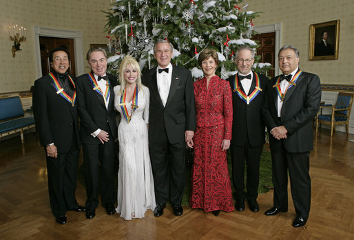 President George W. Bush and Mrs. Laura Bush stand with the Kennedy Center honorees in the Blue Room of the White House during a reception Sunday, Dec. 3, 2006. From left, they are: singer and songwriter William "Smokey" Robinson; musical theater composer Andrew Lloyd Webber; country singer Dolly Parton; film director Steven Spielberg; and conductor Zubin Mehta. White House photo by Eric Draper