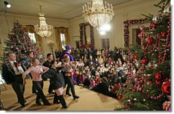 President George W. Bush and Mrs. Laura Bush sit with children of deployed U.S. military personnel and watch a performance of "Willy Wonka" by members of The Kennedy Center Education Department in the East Room Monday, Dec. 4, 2006. White House photo by Eric Draper